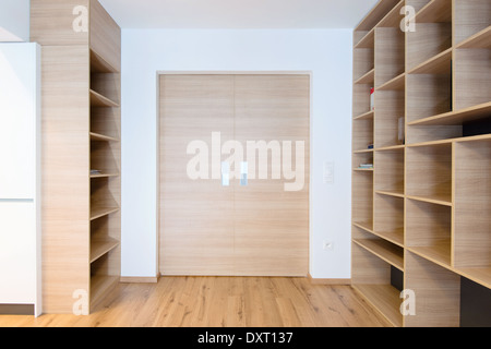 empty bookshelves and closed door in empty apartment Stock Photo