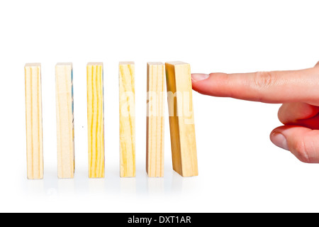 female hand pushing a row of dominoes lined up Stock Photo