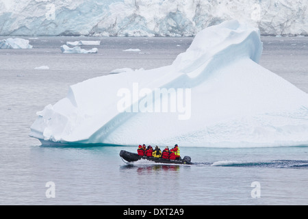 Antarctica tourism among the landscape of iceberg, icebergs, glacier, and ice with tourists in zodiacs. Antarctic Peninsula. Stock Photo
