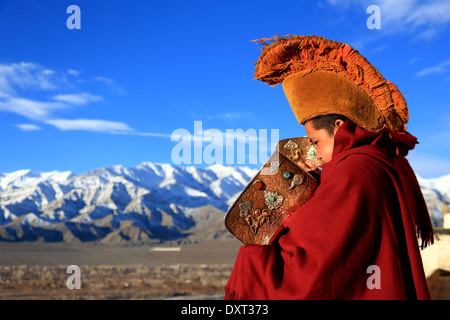 Yellow had monks on a monastery rooftop in Ladakh Stock Photo