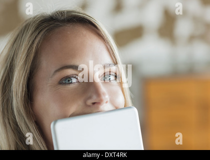 Close up portrait of woman behind digital tablet Stock Photo