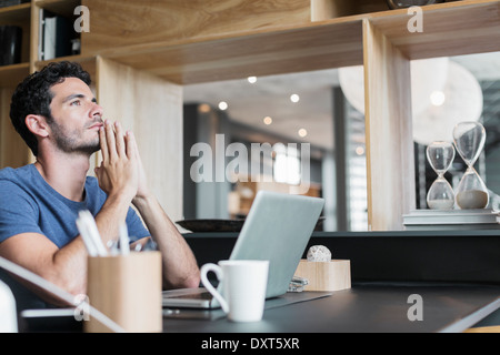 Pensive man at laptop in home office Stock Photo