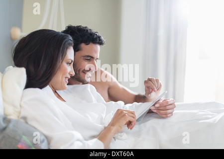 Couple using digital tablet in bed Stock Photo