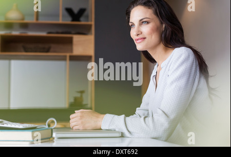 Confident woman sitting at table Stock Photo