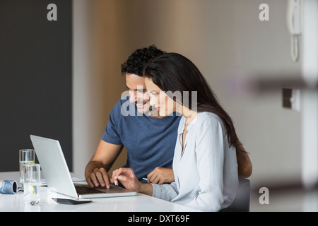 Couple using laptop at table Stock Photo