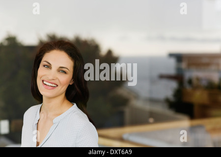 Portrait of woman laughing at window Stock Photo