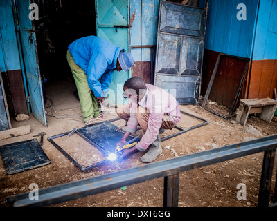 Welder in Kenya, Africa welds steel frames for doors and windows Stock Photo