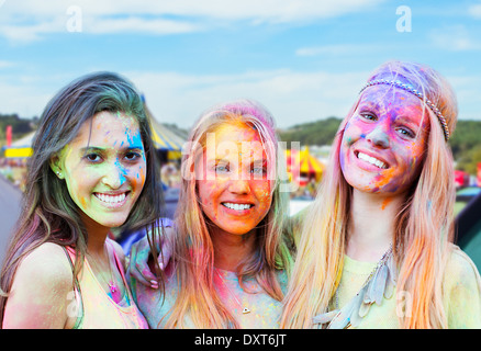 Portrait of smiling women covered in chalk dye at music festival Stock Photo