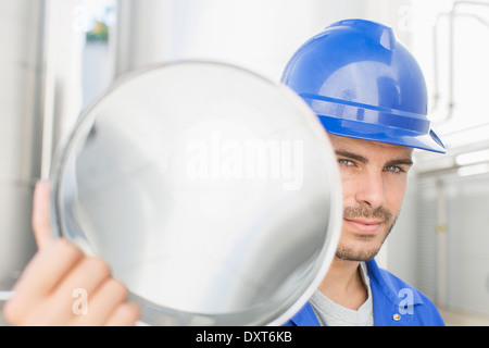 Portrait of confident worker holding stainless steel tube Stock Photo