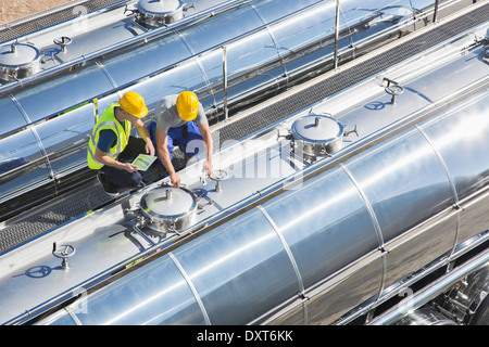 Workers on platform above stainless steel milk tanker Stock Photo