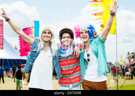 Portrait of cheering friends in wigs at music festival Stock Photo