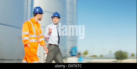 Businessman and worker talking near silage storage towers Stock Photo