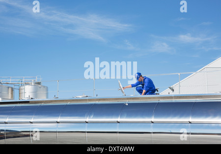 Worker on platform above stainless steel milk tanker Stock Photo