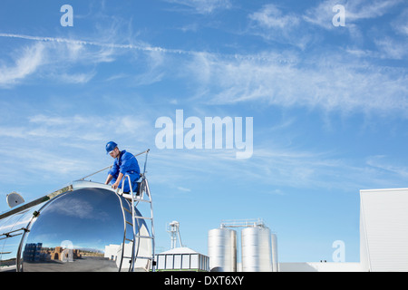 Worker on top of stainless steel milk tanker Stock Photo