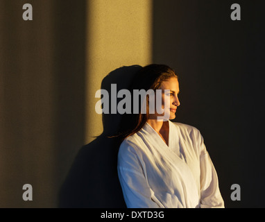 Pensive woman in bathrobe Stock Photo