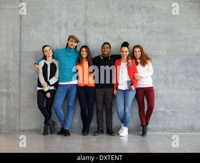 Group of stylish young university students on campus. Multiracial young people standing together against wall in college. Stock Photo