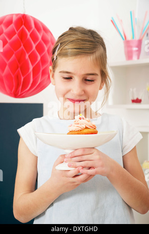 Girl on birthday looking at cake, Munich, Bavaria, Germany Stock Photo