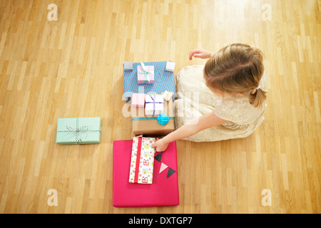 Girl on birthday party unwrapping gift boxes, Munich, Bavaria, Germany Stock Photo