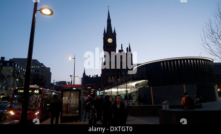 A view of the St Pancras Hotel clock tower building from outside Kings Cross Railway Station forecourt at dusk in London N1 UK  KATHY DEWITT Stock Photo