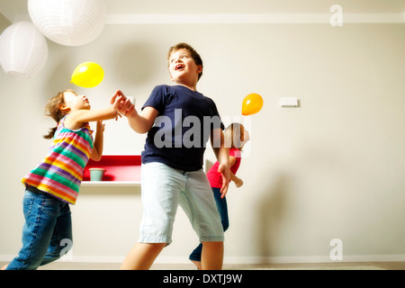 Children in living room playing with balloons, Munich, Bavaria, Germany Stock Photo