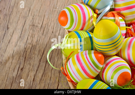 Colorful easter eggs in nest of straw on a wooden table Stock Photo