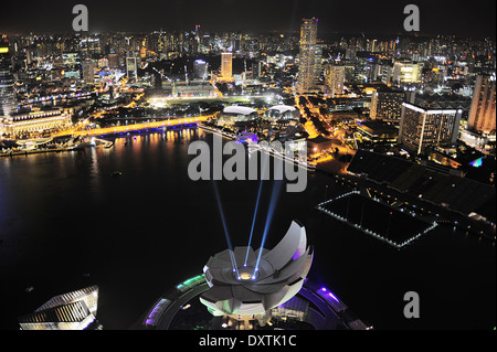 ArtScience museum iluminated in front of Singapore downtown. View from Marina Bay Hotel Stock Photo