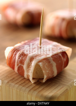 Goat's cheese wrapped in streaky bacon Stock Photo