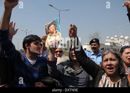 Pakistan, Islamabad. 31st Mar, 2014. Supporters of former Pakistani military ruler Pervez Musharraf flash victory signs as they hold a picture of Musharraf outside a special court hearing treason case against him in Islamabad on March 31, 2014. A Special Court in Pakistan charged Musharraf with high treason -- a crime that carries the death penalty or life imprisonment. Credit:  PACIFIC PRESS/Alamy Live News Stock Photo