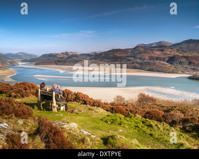 A retired couple seated on a bench at a viewpoint on Panorama Walk overlooking the Mawddach estuary and Cadair Idris range. Stock Photo