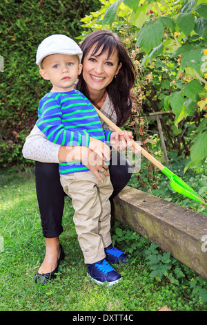 young mother with her son working in the garden Stock Photo