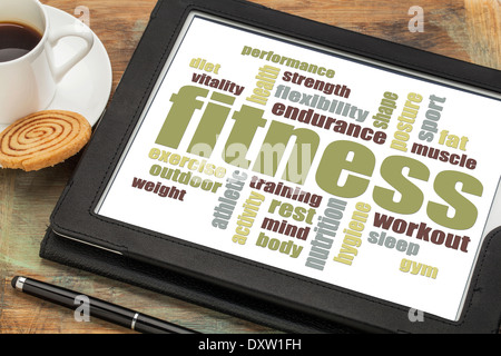 fitness word cloud on a digital tablet with a cup of coffee Stock Photo