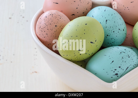Speckled Easter eggs in a variety of colors. Arranged in a heart shaped bowl. Stock Photo