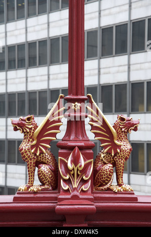 Ornate red gryphons, with details picked out in gold leaf, adorn the Victorian lamp posts on the Holborn Viaduct in the City of London. England, UK. Stock Photo