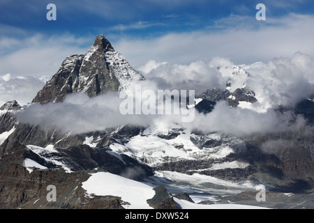 Blue sky and low clouds view of Matterhorn mountain peak from Glacier Paradise in the Swiss Alps near the city of Zermatt Stock Photo