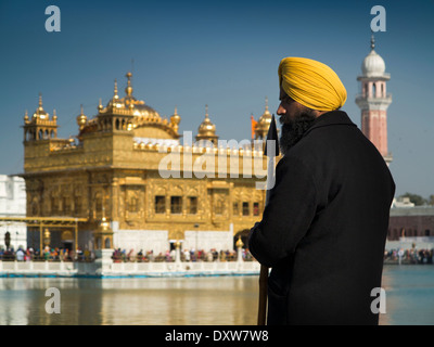 India, Punjab, Amritsar, Sri Harmandir or Darbar Sahib, Golden Temple Sikh guard at edge of Sarovar holy tank Stock Photo