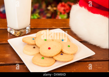 Plate of shortbread cookies with a glass of milk and Santa hat Stock Photo