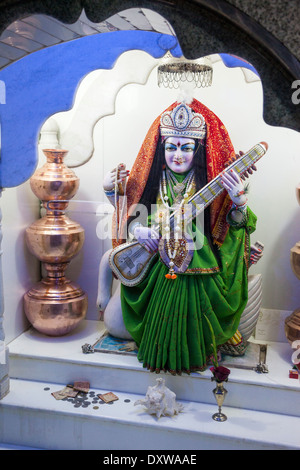 India, Dehradun. Tapkeshwar Hindu Temple. Saraswati Goddess of Education Music and Culture holds a Veena, a Stringed Instrument. Stock Photo