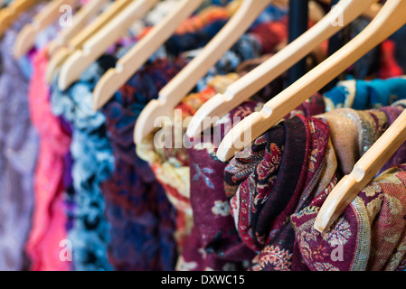 Womans scarves hanging on coat hangers at Christmas market Derbyshire England Stock Photo