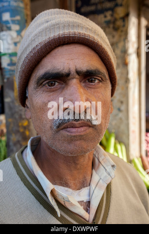 India, Dehradun. Middle-aged Vegetable Vendor in the Market. Stock Photo