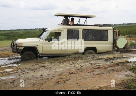 Safari vehicle with tourists, stuck in the mud, Serengeti, Tanzania Stock Photo