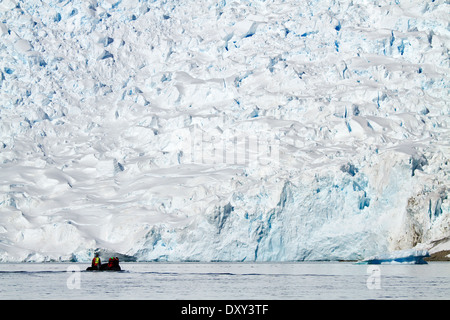Antarctica tourism with cruise ship passengers in zodiac boat viewing Antarctic glacier and iceberg. Stock Photo