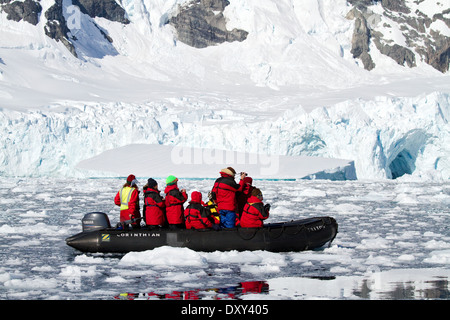 Antarctica tourism with cruise ship passengers in zodiacs boat viewing glacier and iceberg. Stock Photo