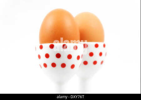 Two eggs in red spotted egg cups studio shot image Stock Photo