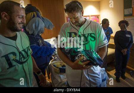 April 1, 2014 - St. Petersburg, Florida, U.S. - Tampa Bay Ray Heath Bell (center) holds newborn Khai Watson as teammate Sean Rodriquez (left) looks on at Bayfront Baby Place Tuesday April 1, 2014. The Rays were there to give special ''Rays Fan for Life'' gifts. Babies born on opening day were given a certificate good for four tickets to all future Rays home openers. ''Im just a tough guy when I play baseball. When it comes down to it I'm just a real gentle giant, I think,'' Bell says. He and his wife have four children ages 4-16. They are thinking about adopting another. ''My wife loves babies Stock Photo