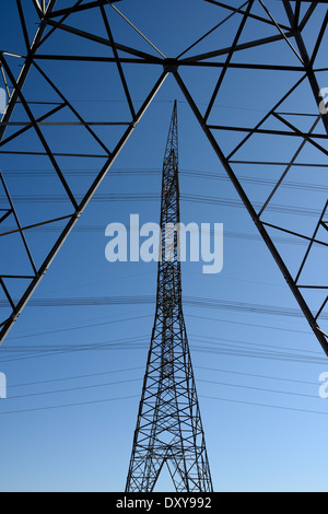 Three symmetrical steel lattice electric towers with high tension power lines Ontario Hydro Stock Photo