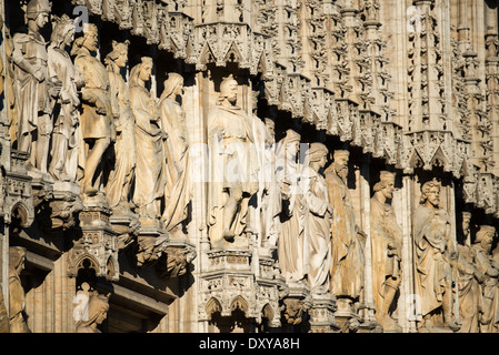 BRUSSELS, Belgium — Ornate statues adorn the exterior walls of Brussels Town Hall, the Gothic masterpiece anchoring Grand Place. The sculptural program, featuring historical figures, saints, and nobles, represents centuries of Belgian artistic heritage. These medieval and neo-gothic statues showcase the evolution of architectural sculpture in Brussels. Stock Photo