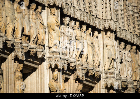 BRUSSELS, Belgium — Ornate statues adorn the exterior walls of Brussels Town Hall, the Gothic masterpiece anchoring Grand Place. The sculptural program, featuring historical figures, saints, and nobles, represents centuries of Belgian artistic heritage. These medieval and neo-gothic statues showcase the evolution of architectural sculpture in Brussels. Stock Photo