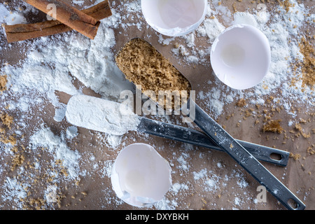 Baker's countertop with broken eggshells, flour, brown sugar and cinnamon sticks Stock Photo