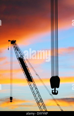 Cranes and cables in front of a stormy sunset sky in Labuan, Malaysia. Stock Photo