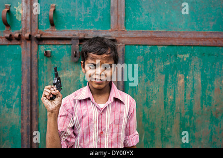 Kid in Agra with a toy gun protecting his area Stock Photo